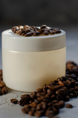 cosmetic jar with coffee beans on background