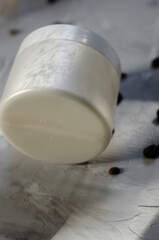 cosmetic jar with coffee beans on background