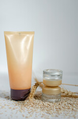 jars for cosmetics on a white background with wheat and oatmeal