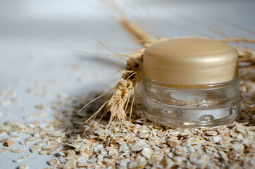 jars for cosmetics on a white background with wheat and oatmeal