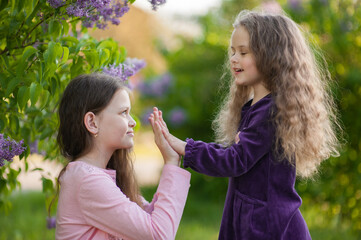 Obraz premium Two sisters play together outside the house in nature.
