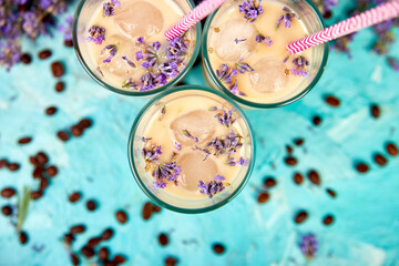 Summer drink iced coffee with lavender in glass and coffee beans on blue background. Good Morning concept. Baeutiful ice coffee.