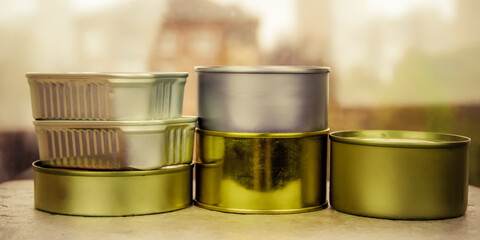 Long-term food supply: stew, meat, fish in cans of various shapes, sizes and colors on the table. Army rations.