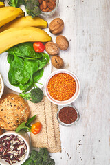 Set of high dietary fibre health food product concept with fruit, vegetables, whole wheat bread, legumes, cereals, nuts and seedson white wooden background . Top view, flat lay, copy space..