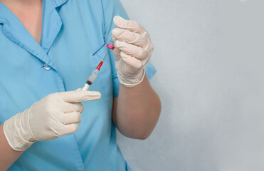 The doctor puts the medicine in a syringe to get the vaccine