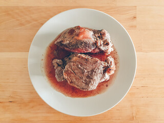 Homemade juicy tenderloin steak dish served on wooden table.