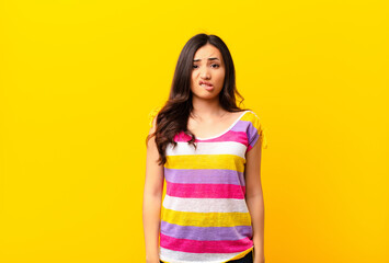 young latin pretty woman feeling clueless, confused and uncertain about which option to pick,...