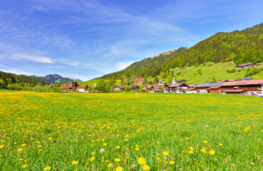 Village Gunzesried surrounded by mountains, fields and forest at a beautiful spring day. Allgäu, Bavaria, Germany