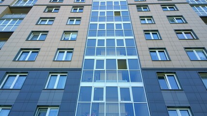 Panel and glass facade of a new multi-story residential building. Concept of sale, rental and insurance of apartments and comfortable house. Housing development. Cityscape. City living. Real estate.