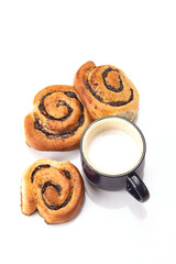 Homemade cream roll with strawberry jam and cup of milk. Isolated on white background.