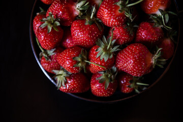 Fresh strawberries on dark moody background. Dark food photography.