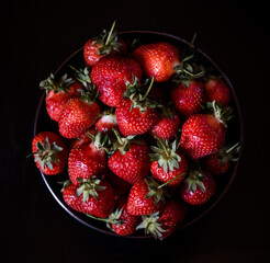 Fresh strawberries on dark moody background. Dark food photography.