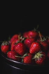 Fresh strawberries on dark moody background. Dark food photography.