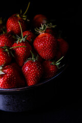 Fresh strawberries on dark moody background. Dark food photography.