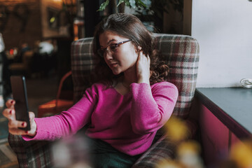 Beautiful female making photo while sitting in cafe