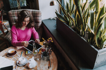 Attractive busy woman working while sitting in cafe