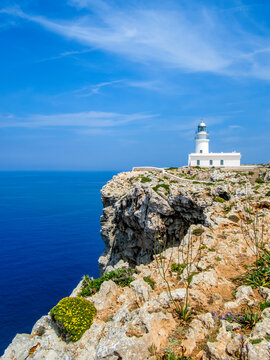 idyllic view to the cape cavalleria lighthouse in front of steep cliffs at the mediterranean sea nearby es mercadal, minorca