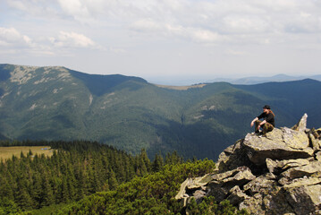 A human traveler enjoys the view of the mountains.Relaxing meditation on the top of a mountain.