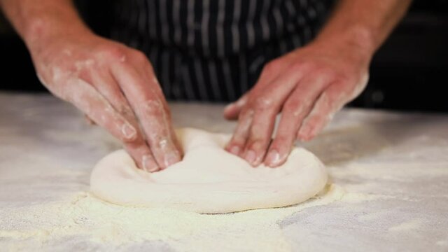 The chef prepares pizza on a white table in a top restaurant