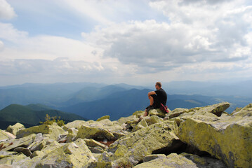 A human traveler enjoys the view of the mountains.Relaxing meditation on the top of a mountain.