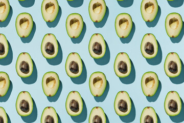 Pattern of cut avocado on blue background, healthy eating concept