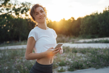 Girl with smartphone at sunset