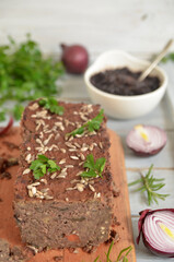 Lentil and eggplant pate on a wooden board on a light wooden background