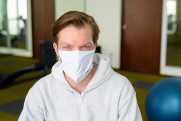 Face of young man with mask sitting at the gym