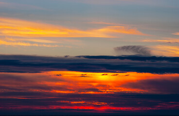 Fototapeta na wymiar Vibrant cloudy sunset over dark blue ocean