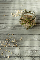 Oat groats in a jar and scattered on a table