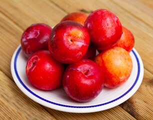 Naklejka na ściany i meble Image of fresh ripe red plums, harvest from garden