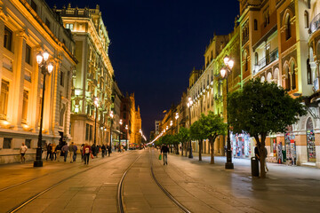 Fototapeta na wymiar Night view of an illuminated street in the center of Seville, Spain.