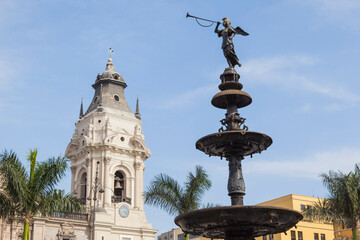 Historic Statue of Angel of the Fame on the Fountain at Plaza Mayor with Basilica Cathedral of Lima, Peru