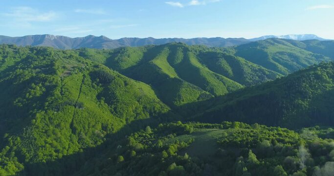 Aerial view of beautiful serene green hills and mountain tops in the spring