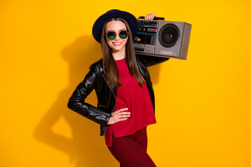 Portrait of her she nice attractive lovely cute fashionable pretty charming cheerful cheery straight-haired girl carrying boombox isolated over bright vivid shine vibrant yellow color background