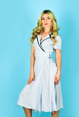 Clothes shop. Beauty and fashion. Curly blonde in blue dress. Girl wearing vintage outfit long simple dress. Beautiful retro woman romantic look. Pin up girl in retro dress. Stylish vintage and sexy