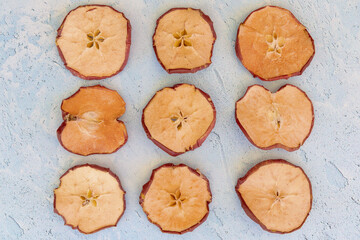 Arrangement of dried apple and dried orange slices on blue background