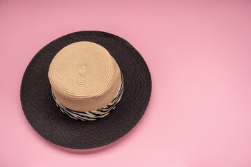 Fototapeta na wymiar Beach straw hat for sun protection on a pink background. Close-up. Copy space.