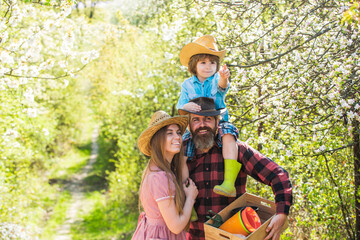 Lovely family outdoors nature background. Ranch concept. Happy family day. Parents growing little baby. Spend time together. Mother father and cute son. Family farm. Farmers in blooming garden