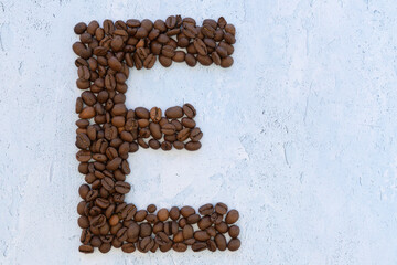 Letters made out of coffee beans on blue background