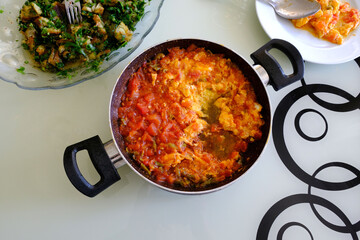 menemen dinner made with tomatoes and eggs in the pan for breakfast,