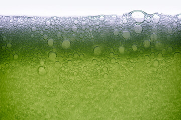 Background of close-up soda bubbles mixed with lemon juice or green juice on white background.