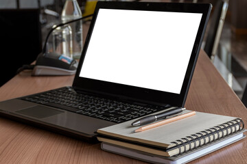 Laptop with a pen and notebook on the table in meeting room