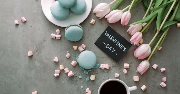 Top View, Note "Valentine's Day" on Table with Background of Macarons and Fresh Tulips, and Marshmallow with Cup of Coffee