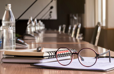 Glasses, pen, pencil, and notebooks in meeting room