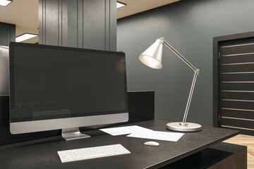 Designer desktop with black computer screen and lamp.