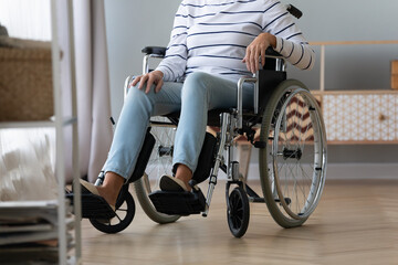 Unable to walk aged handicapped woman sitting in wheel chair cropped image view of old female lower...