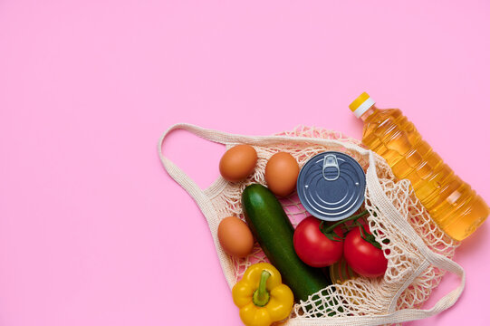 Fresh vegetables and foods in the string bag. Chicken eggs, zucchini, tomatoes, sunflower oil, yellow fresh pepper