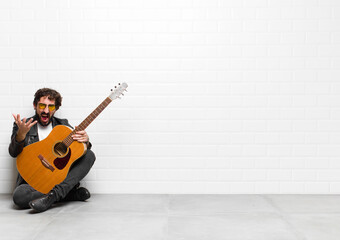 young musician man looking angry, annoyed and frustrated screaming wtf or what’s wrong with you...