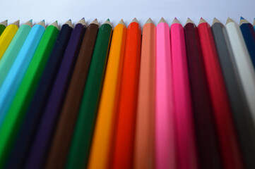 Ordered colored pencils in a raw - colorful background